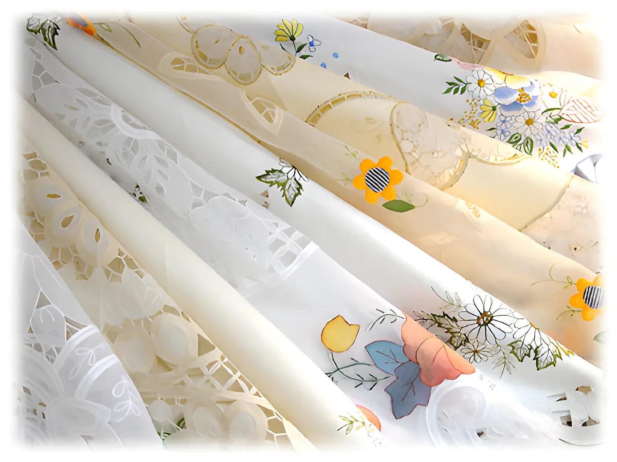 Folded tablecloths with floral embroidery in white and pastel